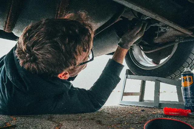 Майстер СТО AutoWizard оглядає підвіску автомобіля на підйомнику